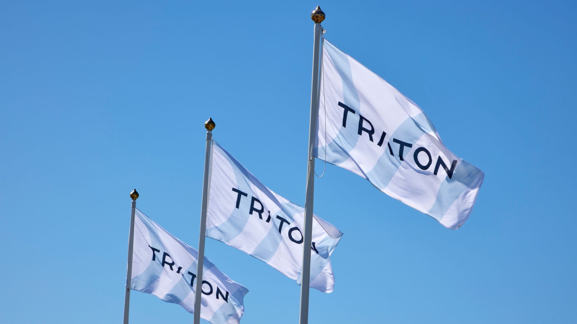 three company flags with the logo of TRATON