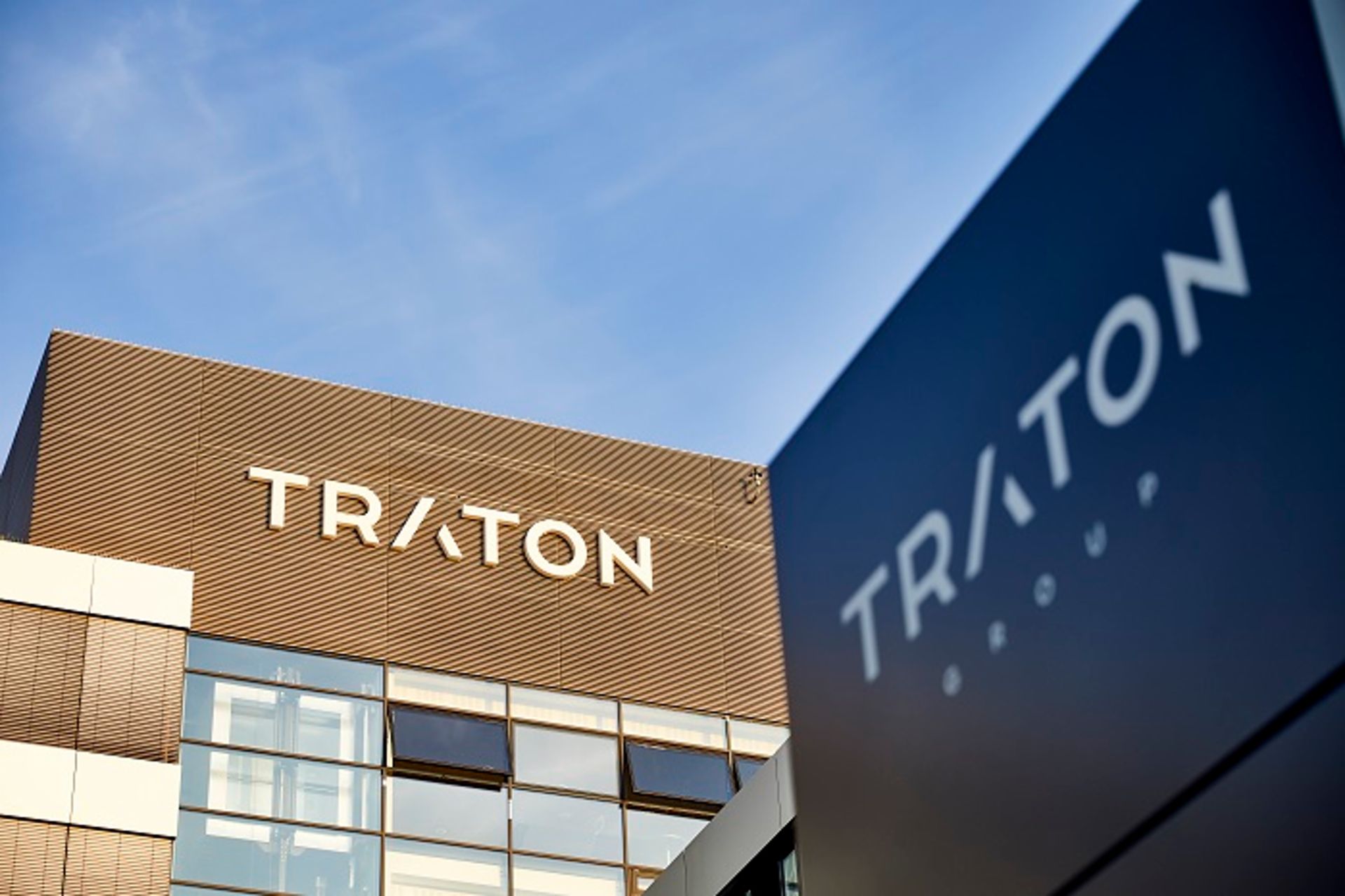 Photo of TRATON building with the logo on the wall on a sunny day
                 